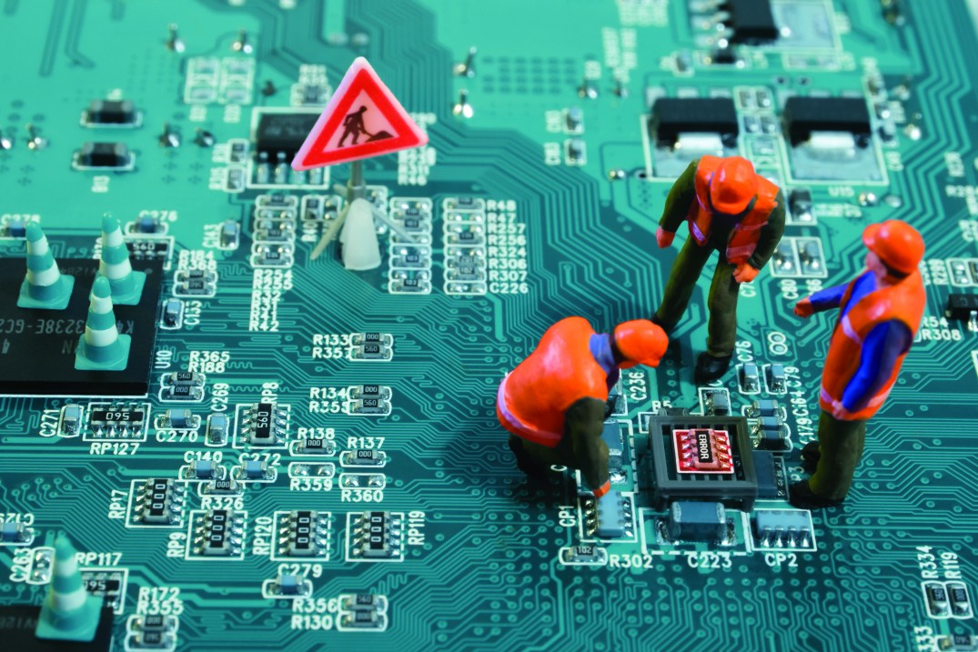 Miniature engineers fixing error on chip of motherboard